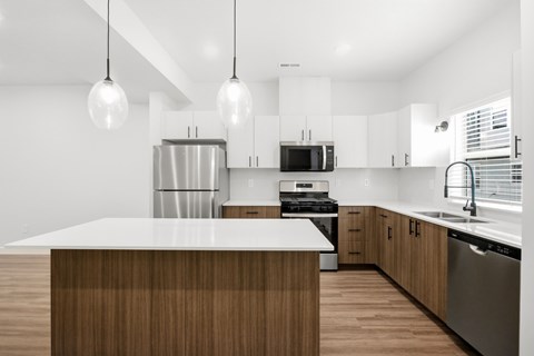A modern kitchen with a wooden island and stainless steel appliances.