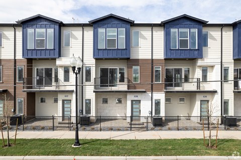 a row of town houses with balconies and a sidewalk