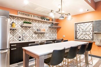 A kitchen with orange walls and a white table.