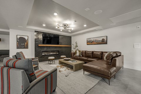 A living room with a fireplace and a brown couch.
