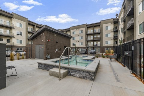 A pool in a courtyard surrounded by buildings.