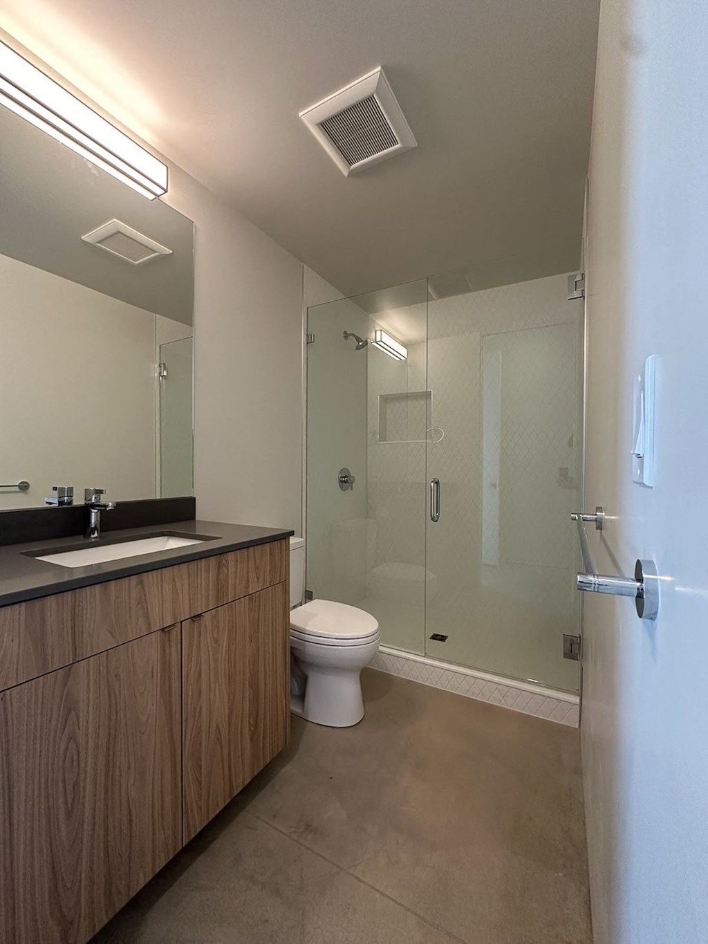 A bathroom with a toilet, sink, and shower.