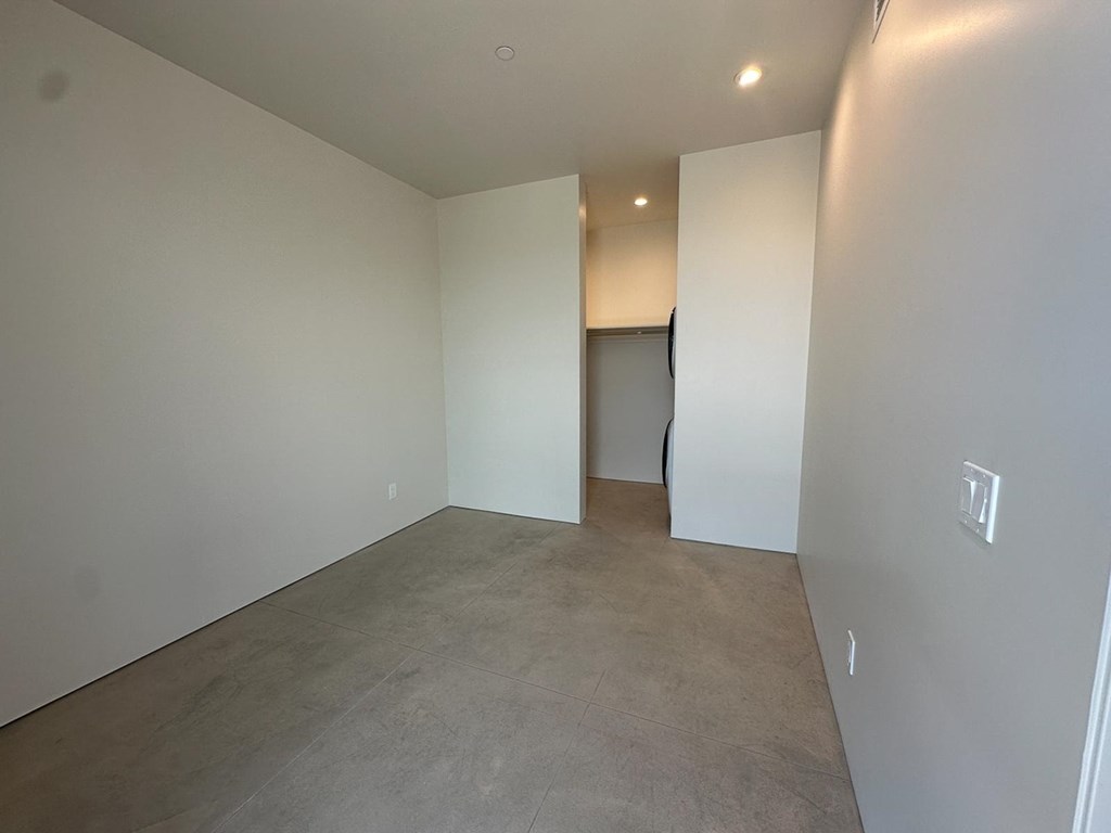 a empty living room with white walls and a concrete floor