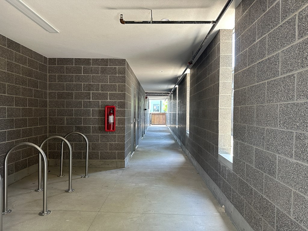 a hallway in a building with a red fire hydrant in the middle