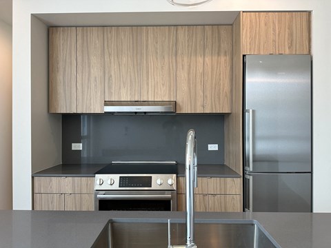 A modern kitchen with wooden cabinets and stainless steel appliances.