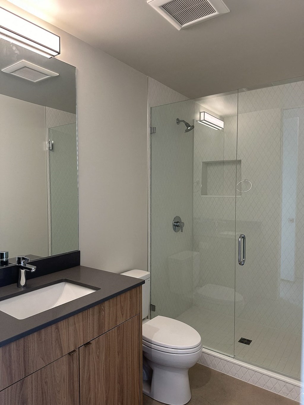 a modern bathroom with a glass shower and toilet