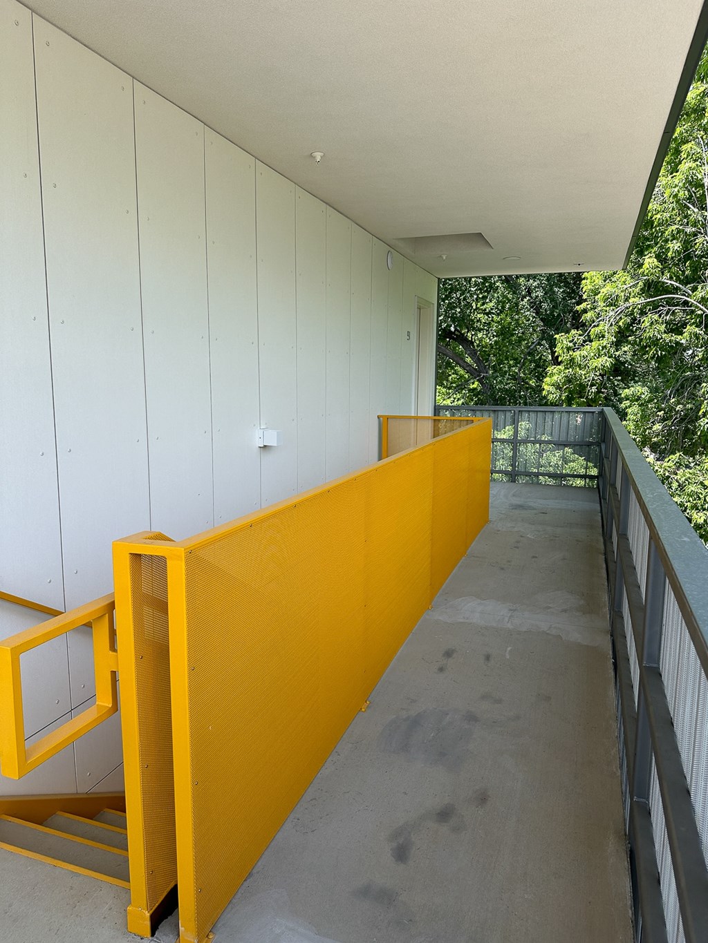 A yellow staircase with a metal railing.