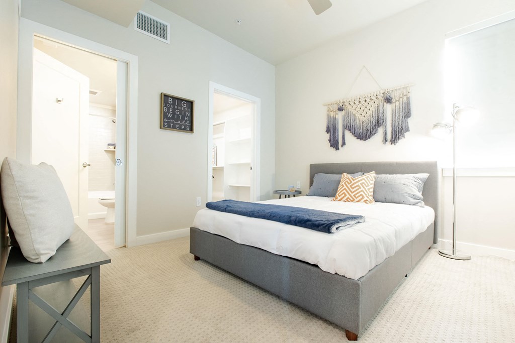 a bedroom with a bed and a door to a bathroom