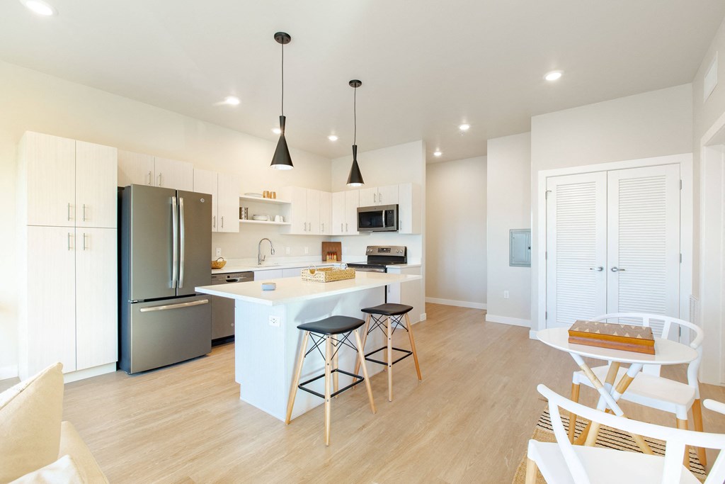a large kitchen with a white island and stainless steel appliances