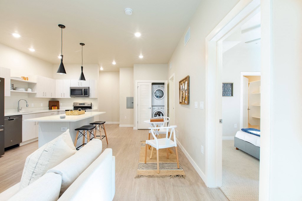 a living room and kitchen with a white couch and a table
