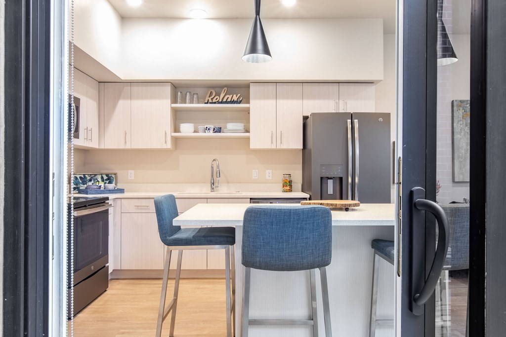 a kitchen with a white counter top and blue chairs