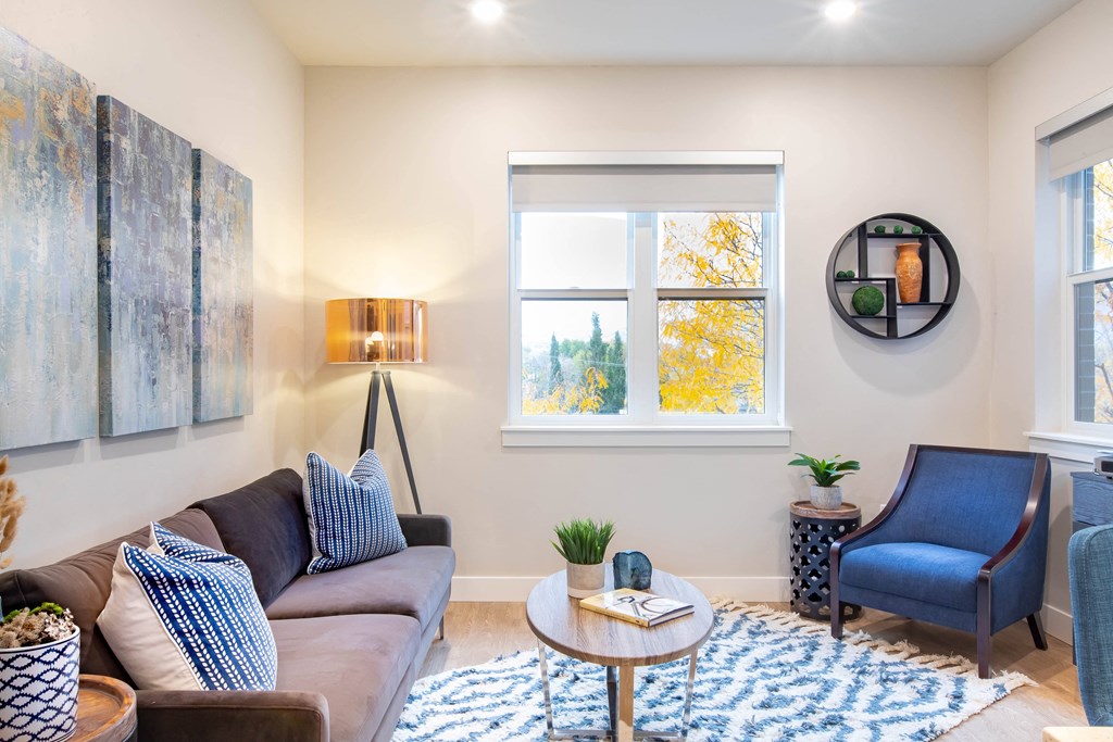 a living room with a couch and a chair and a window