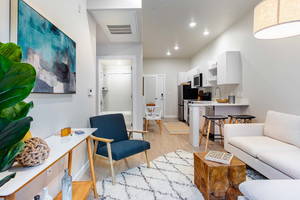 a living room with a couch and a chair and a kitchen