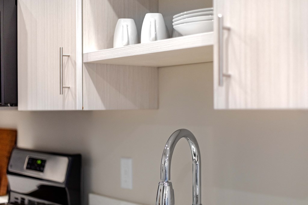 a kitchen with white cabinets and a sink and a faucet