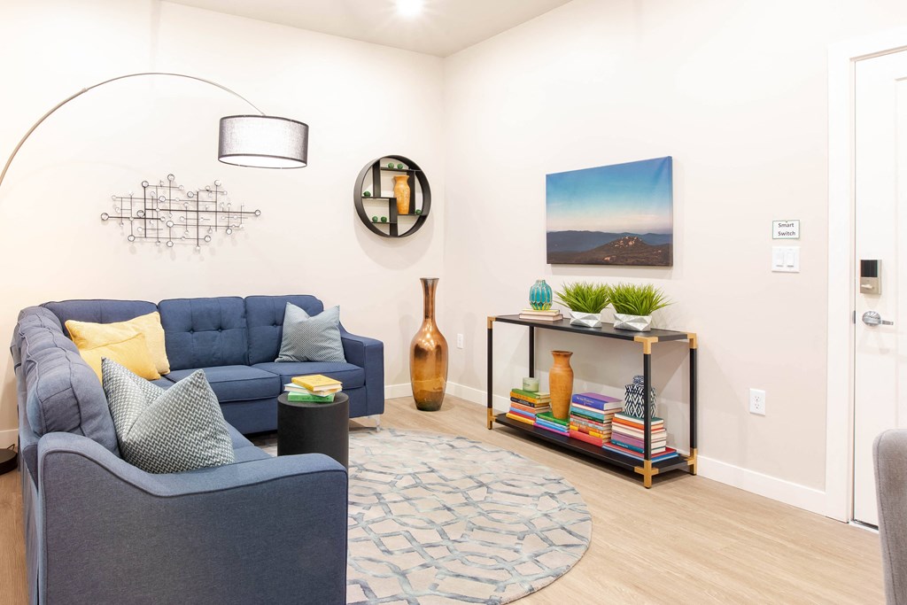 a living room with blue couches and a rug