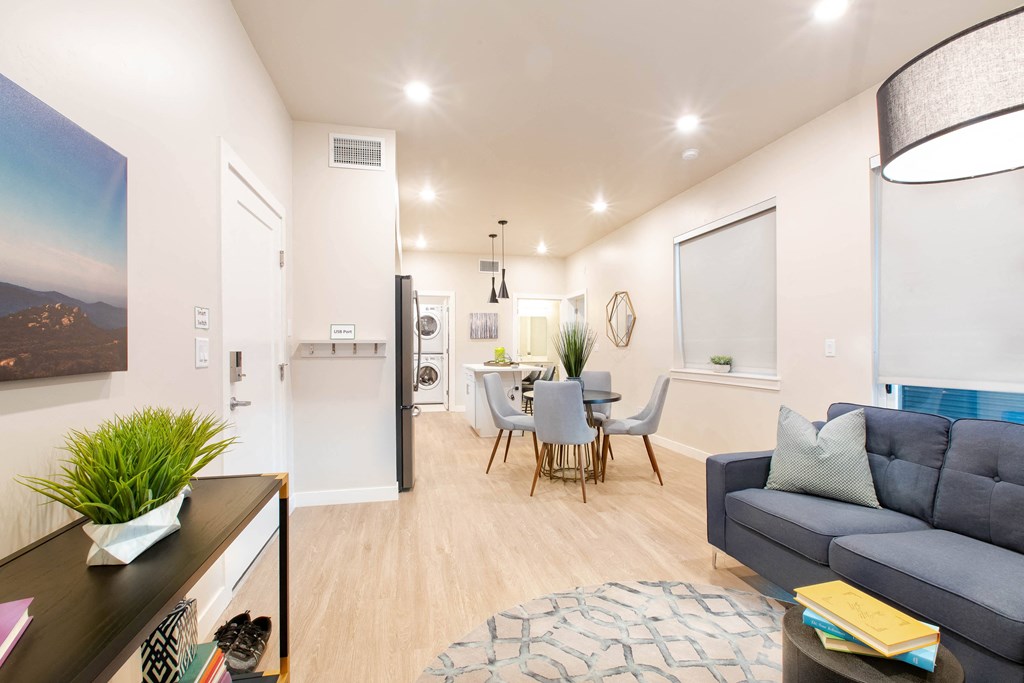 a living room with a blue couch and a dining room table