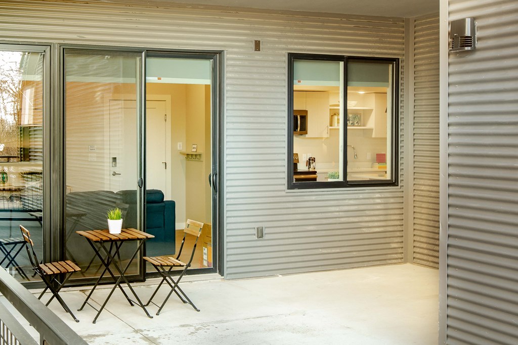a patio with a table and chairs and sliding glass doors
