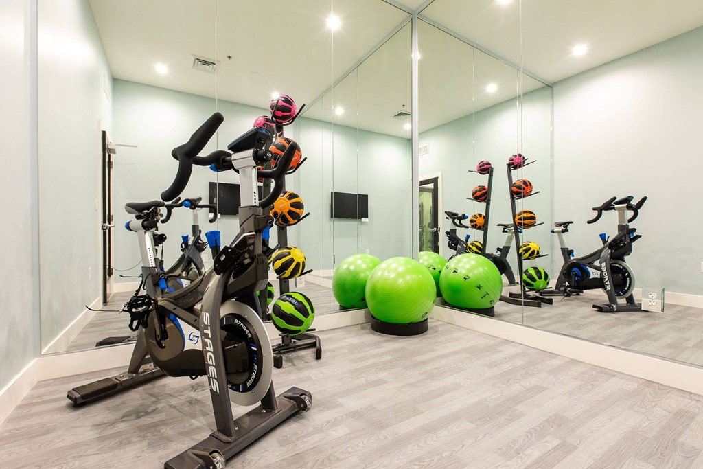 a gym with exercise bikes and weights in a glass wall