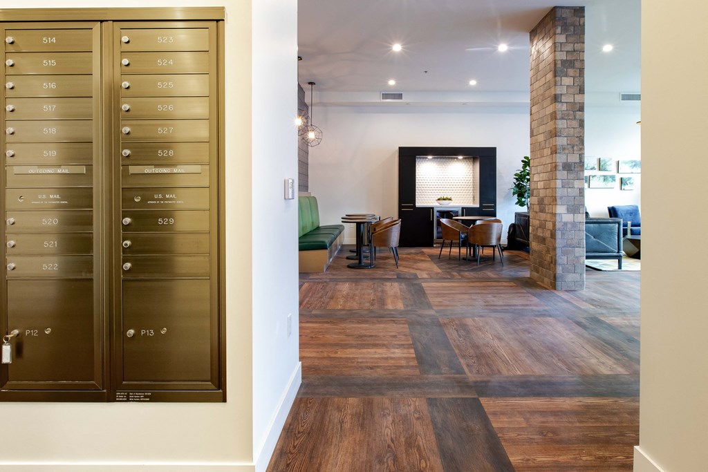 a view of a living room and dining room from a hallway with a large door