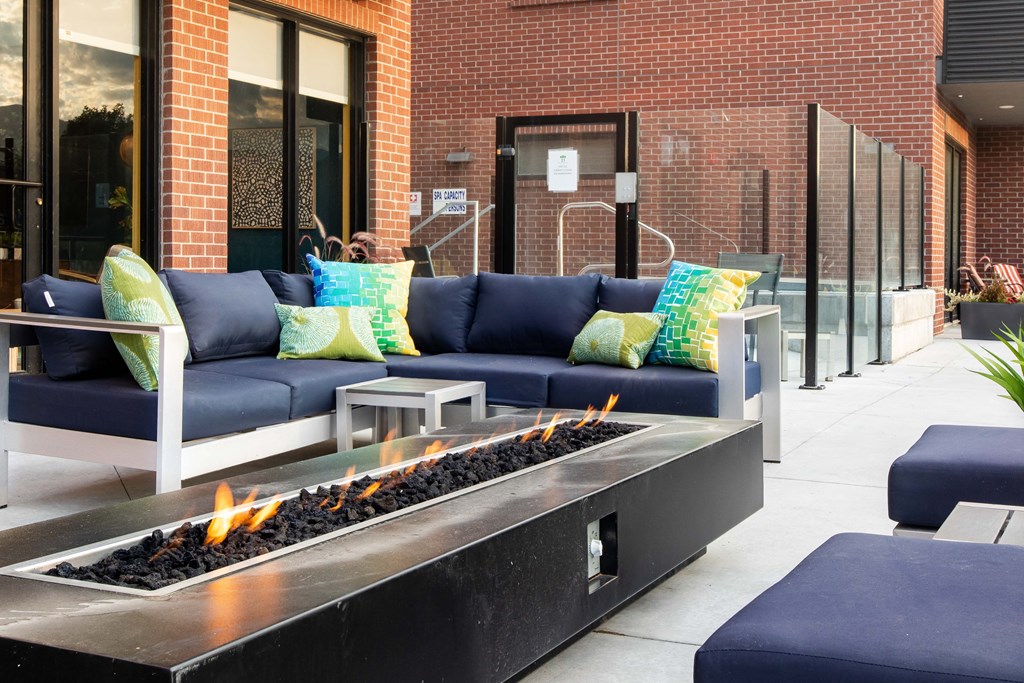 an outdoor seating area with couches and a fire pit