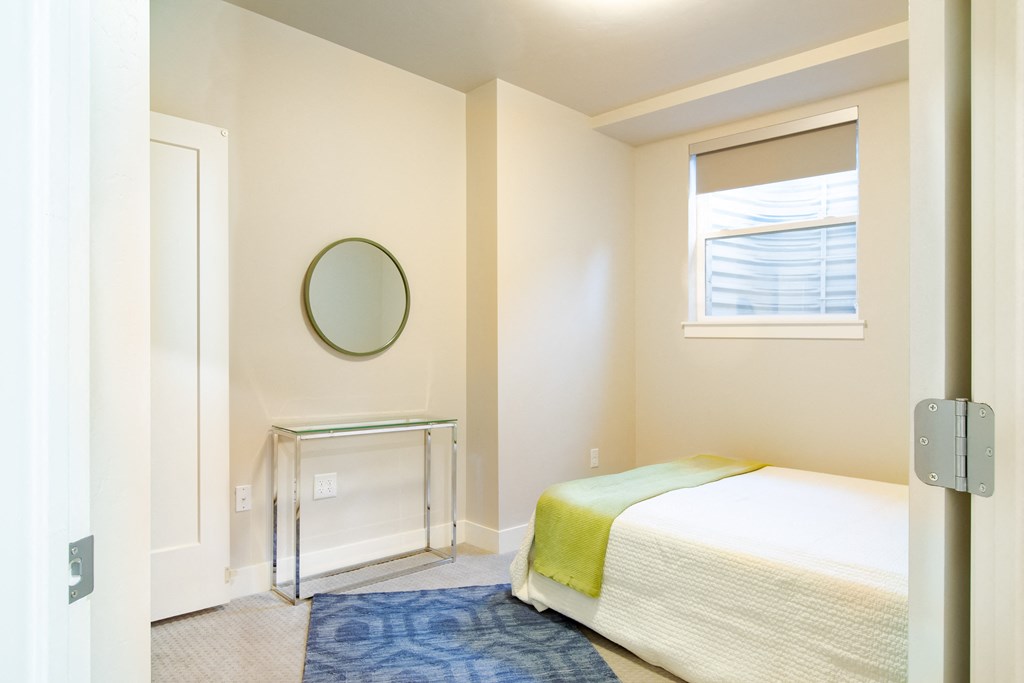 a small bedroom with a bed and a window