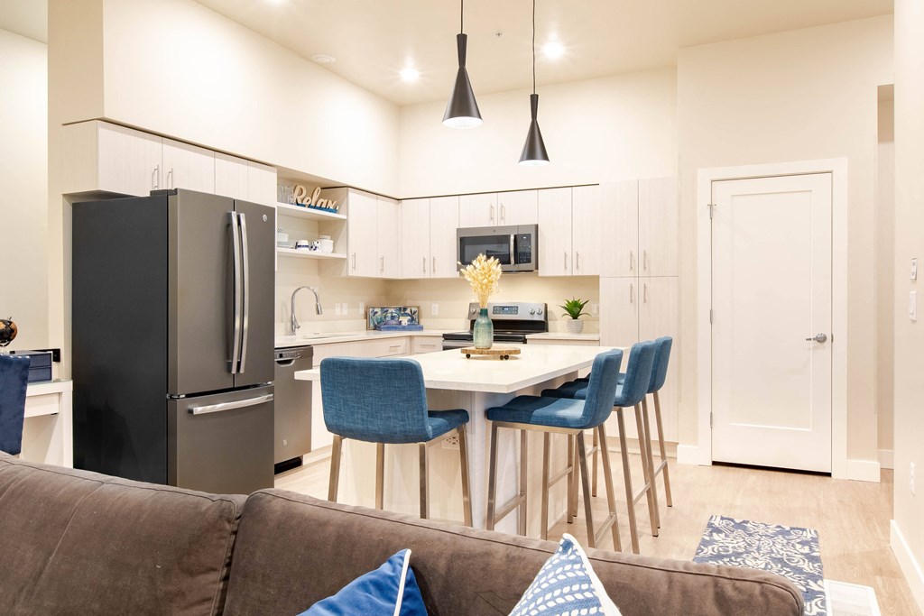 a living room with a kitchen with a table and chairs