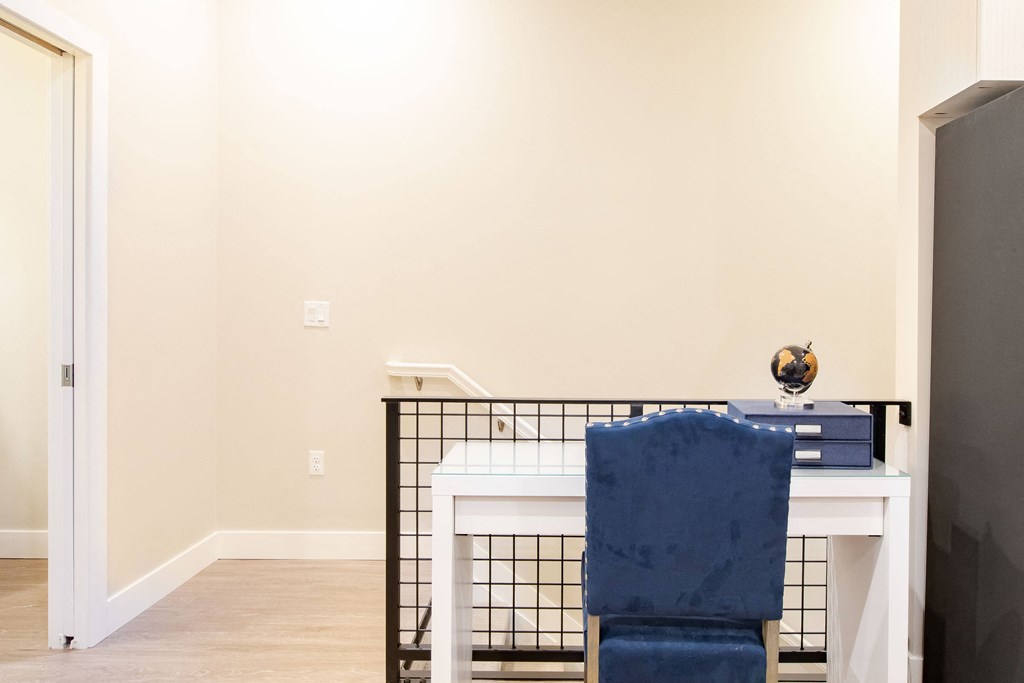 a home office with a white desk and a blue chair