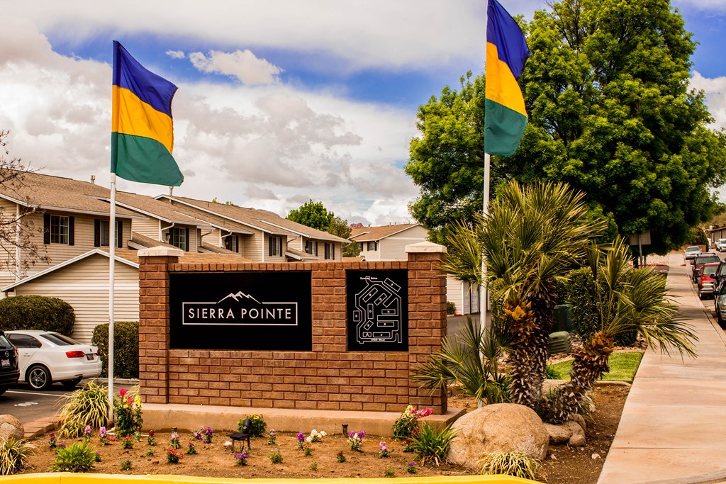 the pointe sign in front of a brick building with flags on the