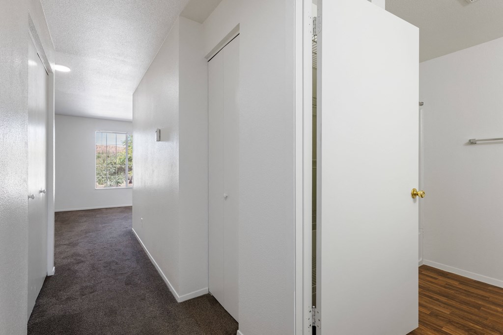 an empty room with white walls and a door to a closet
