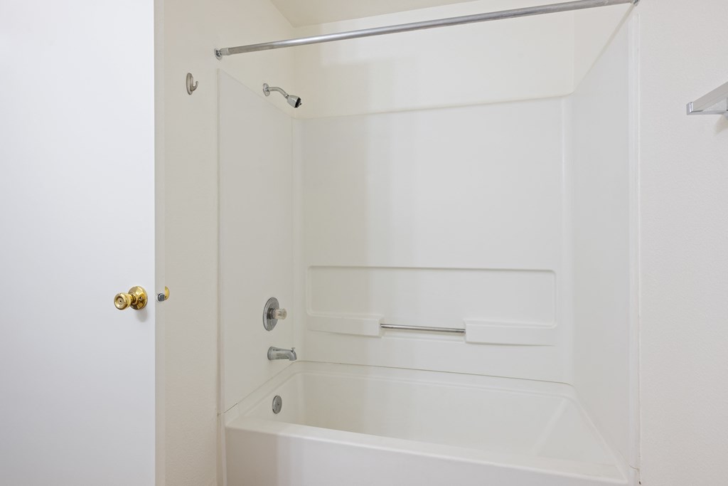 a white bathroom with a shower and a tub