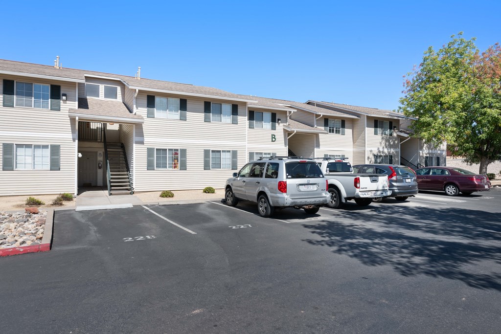 a parking lot with cars in front of an apartment building