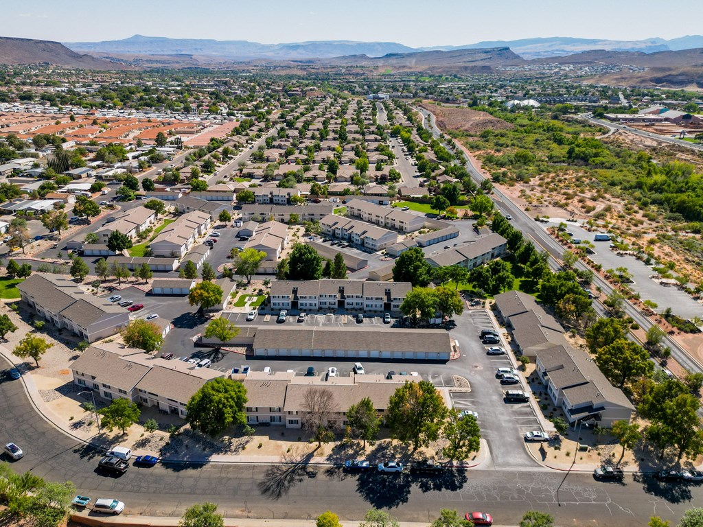 an aerial view of a neighborhood of houses and cars in a parking lot