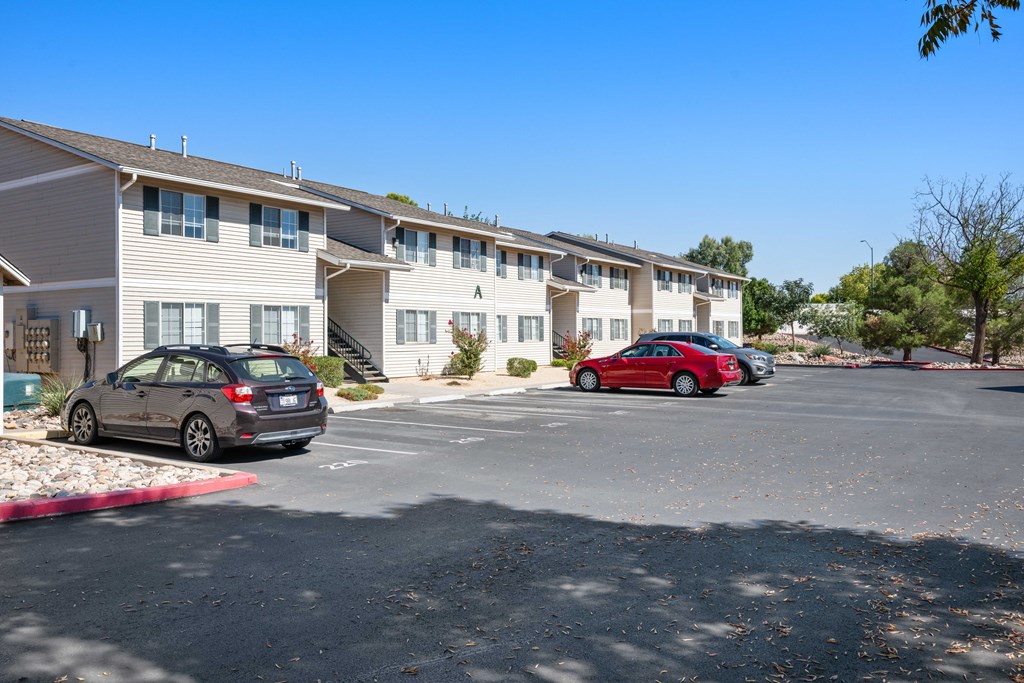 a parking lot with cars in front of apartment buildings