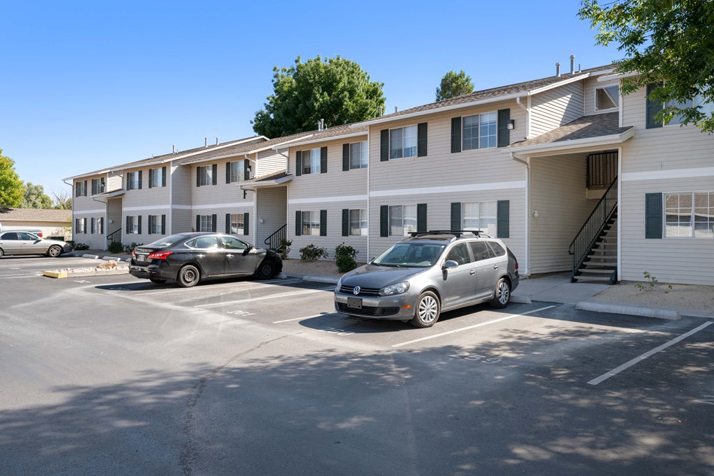 a parking lot with cars in front of an apartment building
