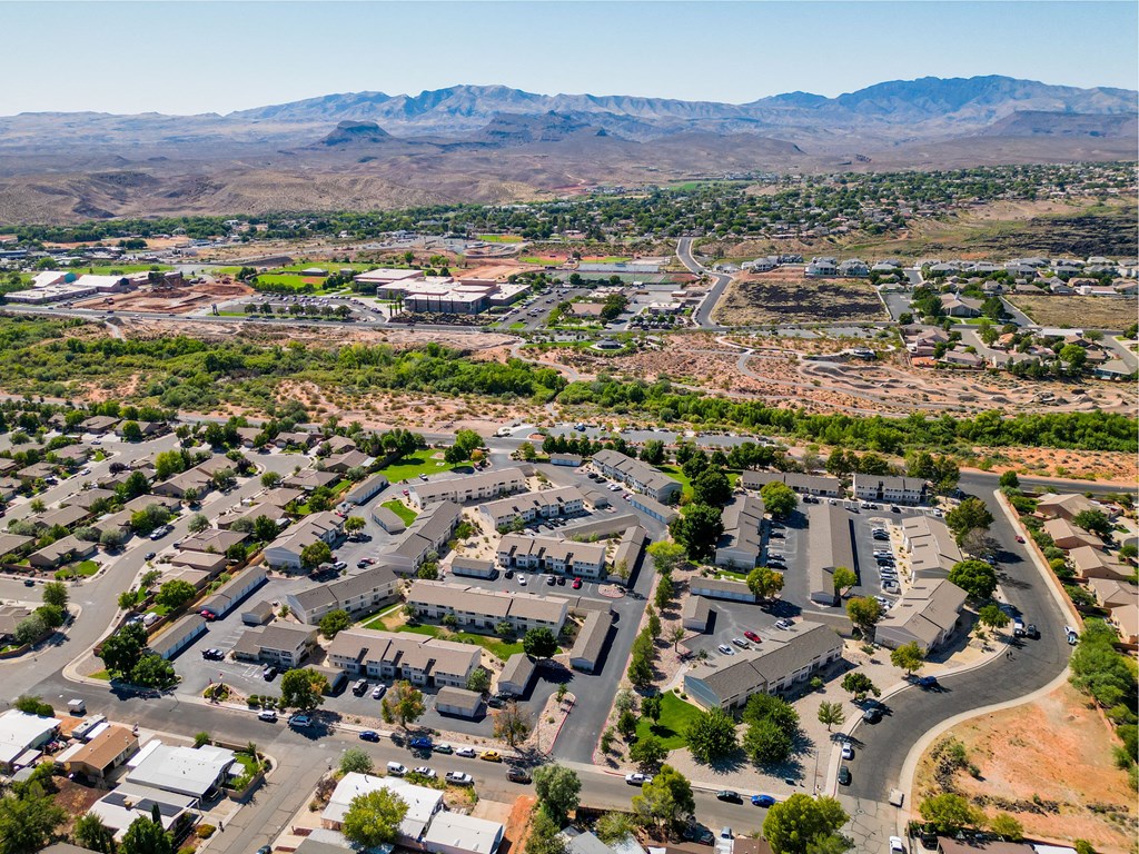 an aerial view of a city with cars parked in a parking lot