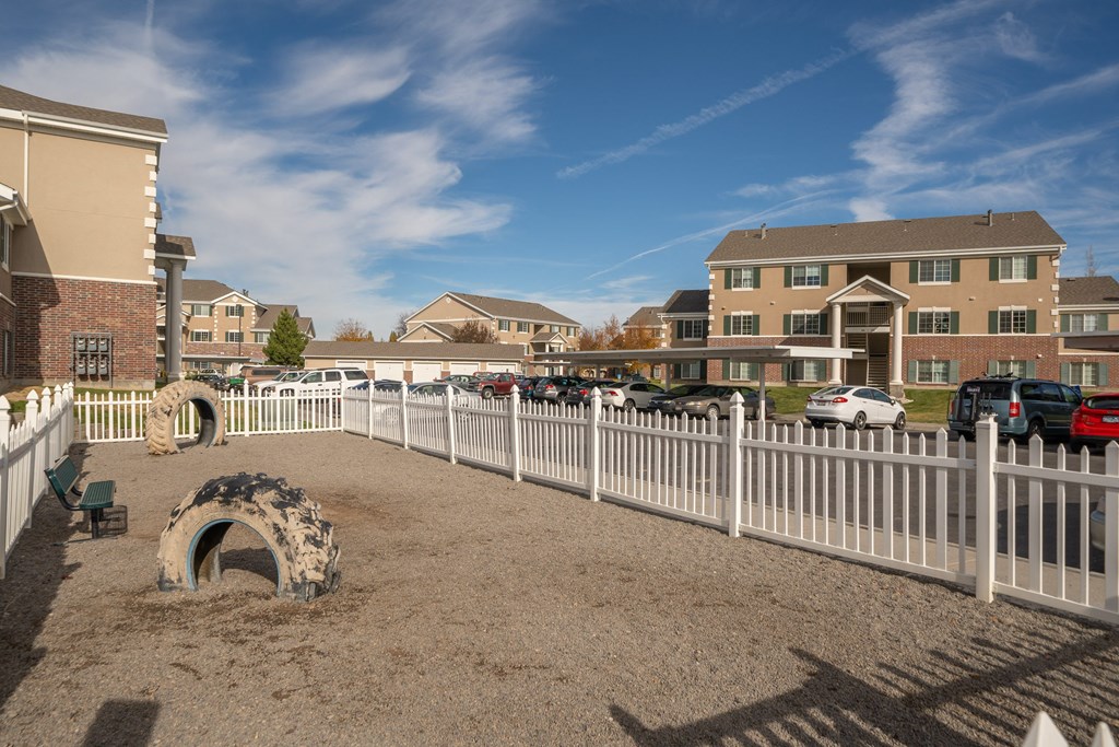 a fenced in dog park in front of a building