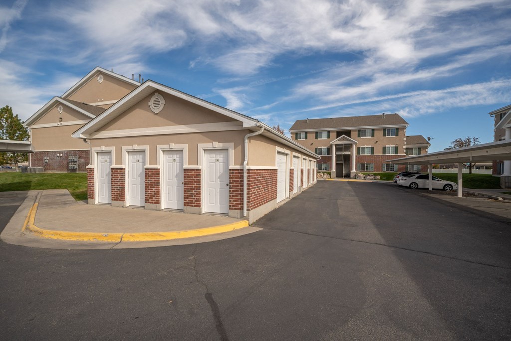 the front of a building with a driveway and a parking lot
