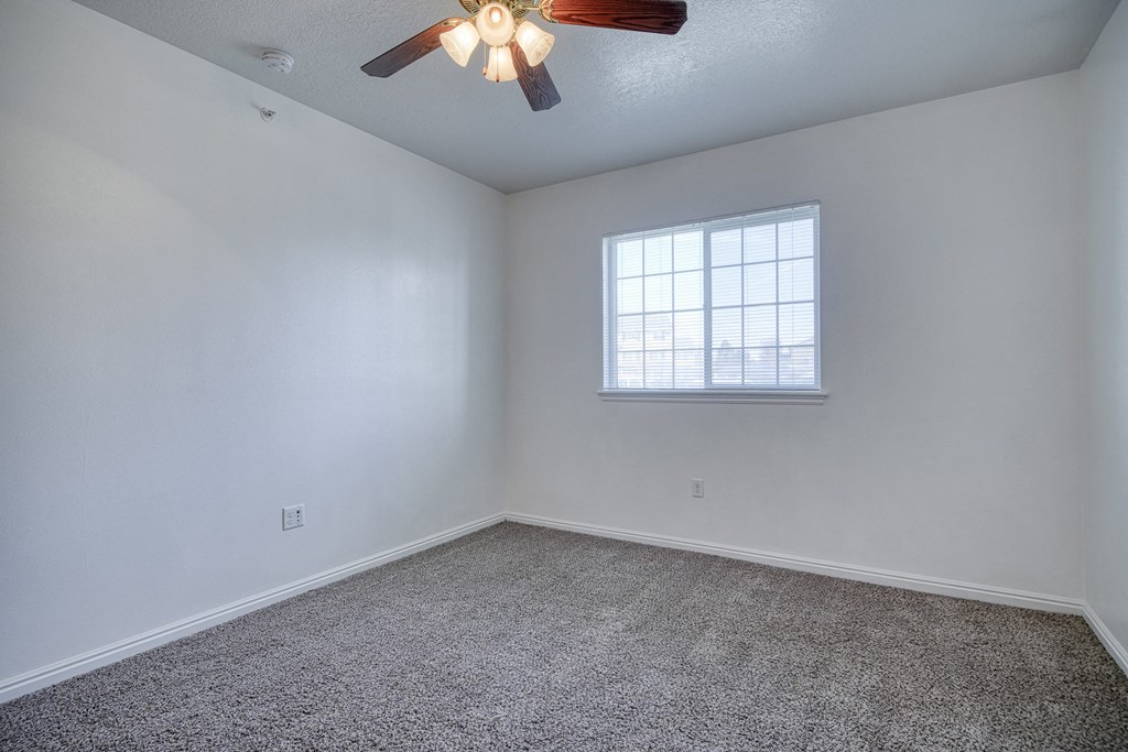 a bedroom with a ceiling fan and a window