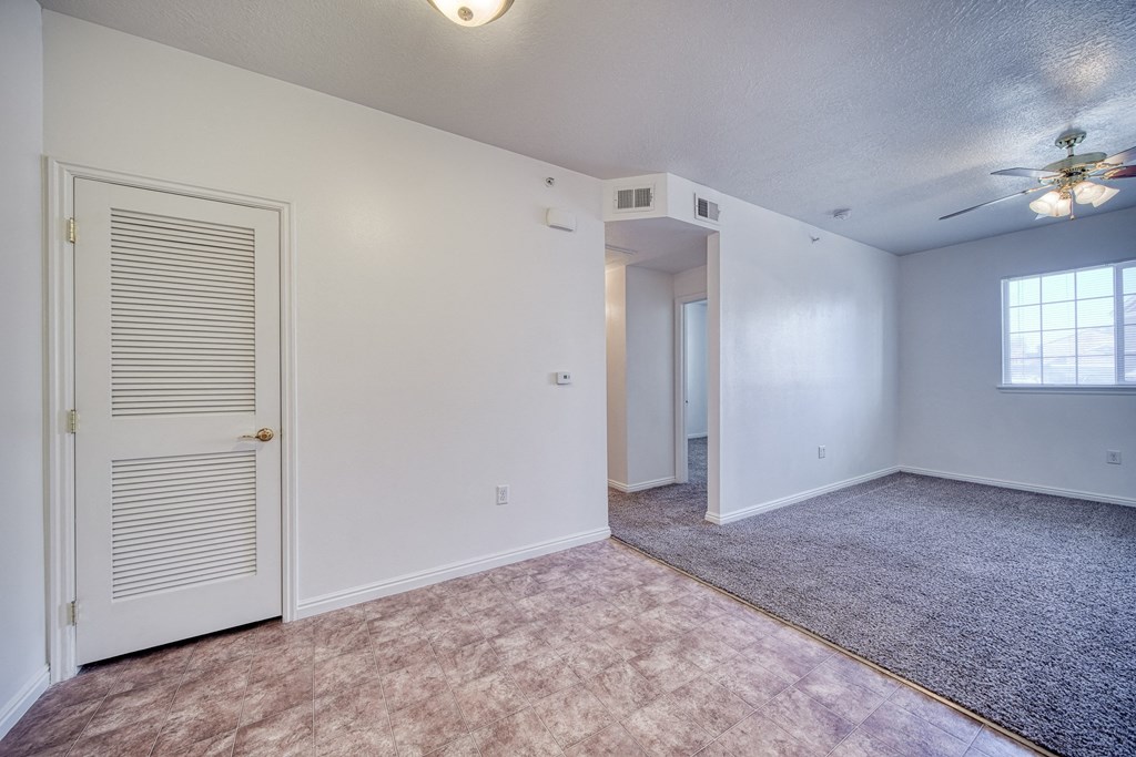 a bedroom with a ceiling fan and carpet