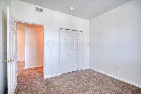 a bedroom with white walls and carpet