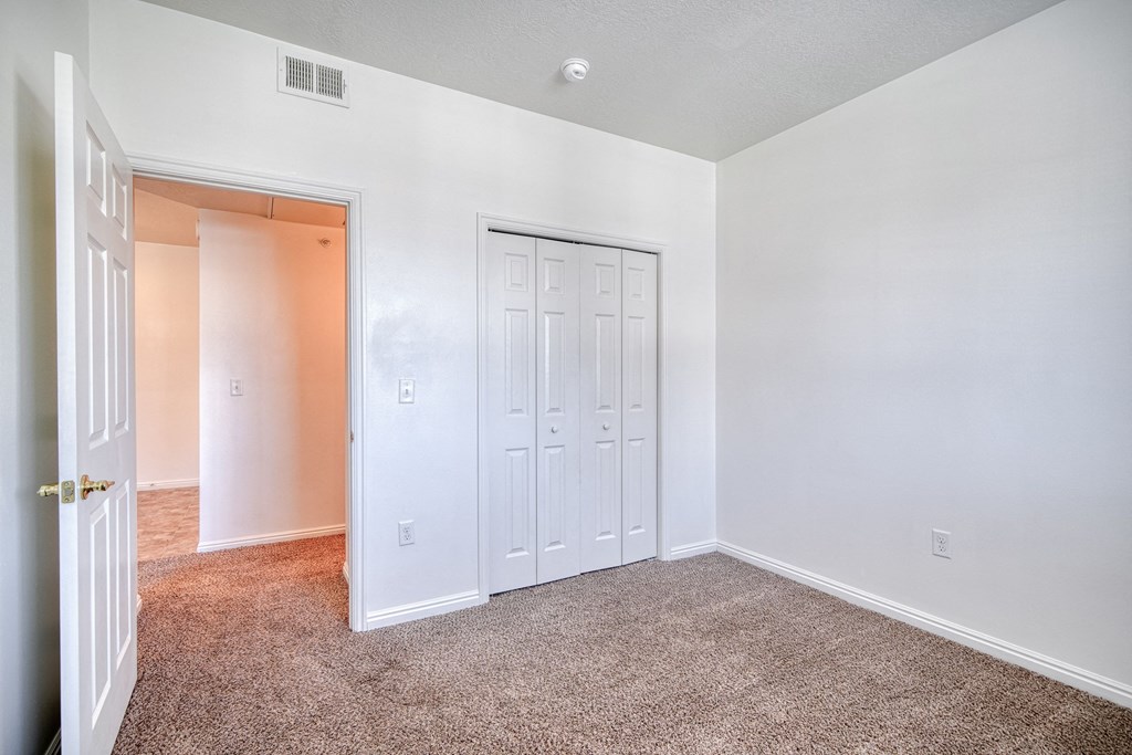 a bedroom with white walls and carpet