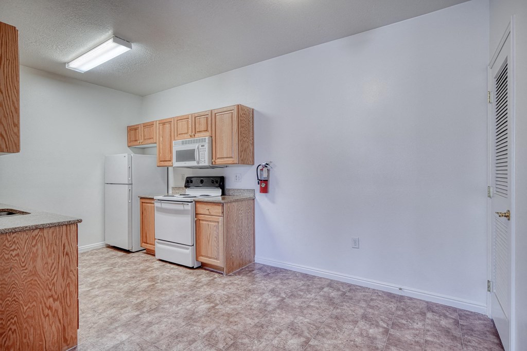a kitchen with white appliances and wooden cabinets