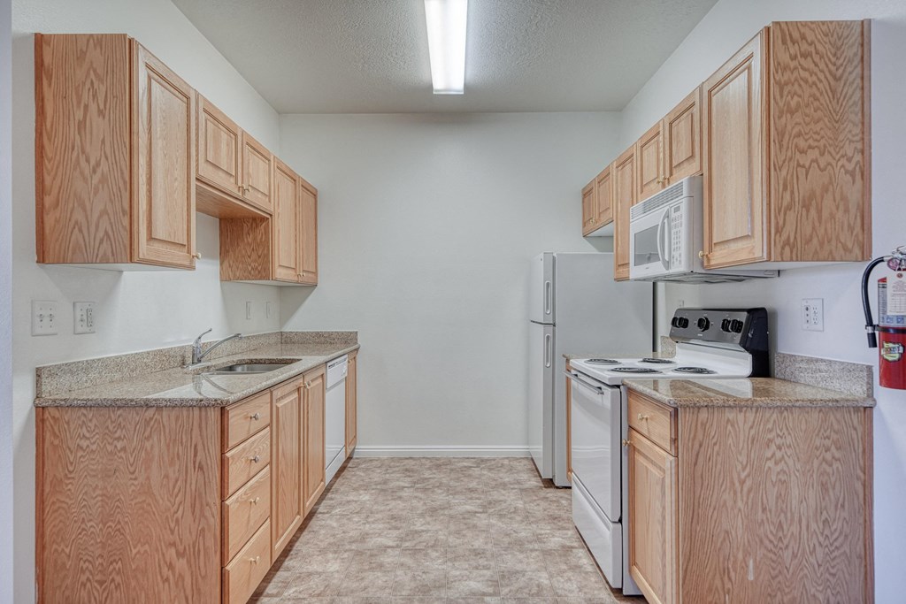 a kitchen with wood cabinets and white appliances