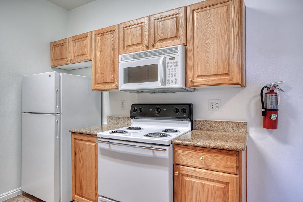 a kitchen with white appliances and wooden cabinets