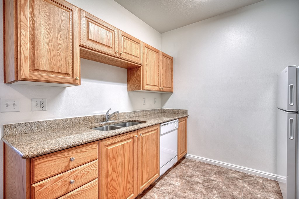 a kitchen with wooden cabinets and a white dishwasher