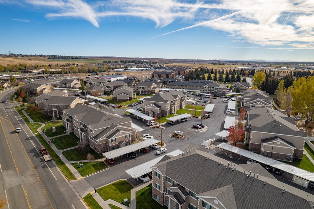 an aerial view of a neighborhood of houses with cars parked on the street