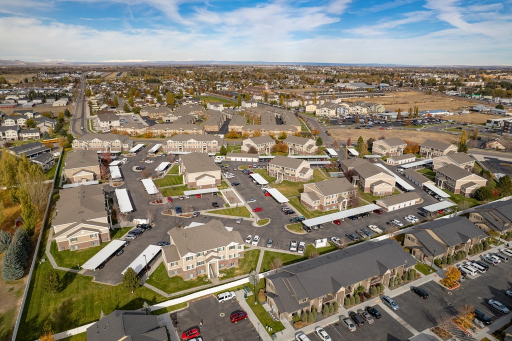 an aerial view of a neighborhood of houses and cars in a parking lot