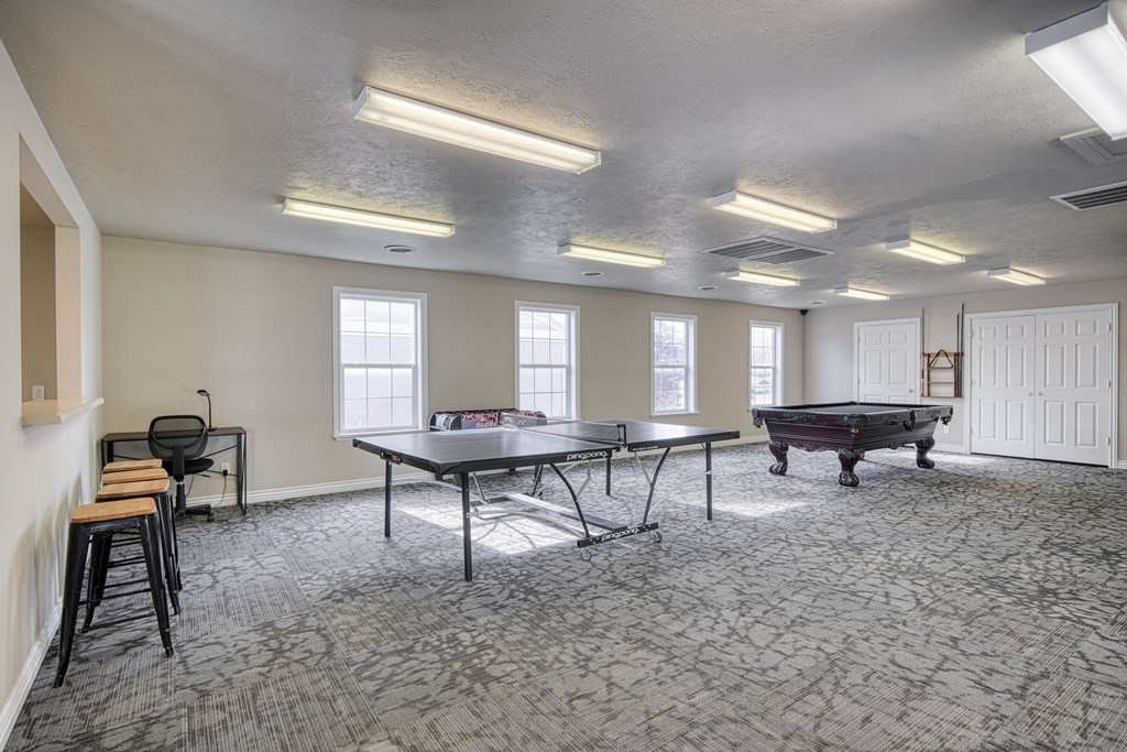 a games room with two ping pong tables and a foosball table