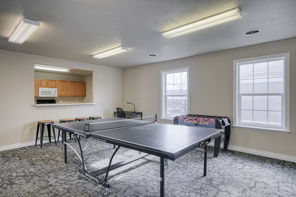 a room with a ping pong table and a couch