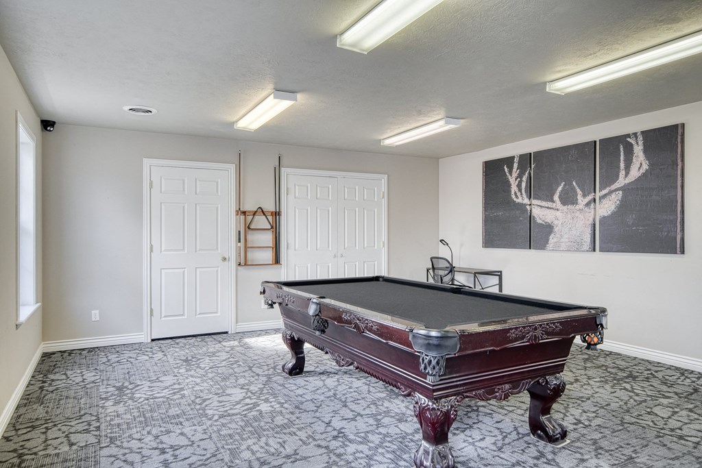 a game room with a pool table and a chalkboard on the wall